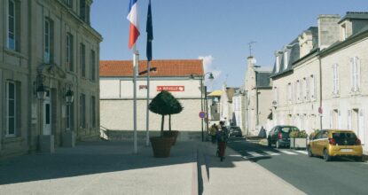 Drapeaux français et européen devant une mairie, formation clauses environnementales et sociales marchés publics